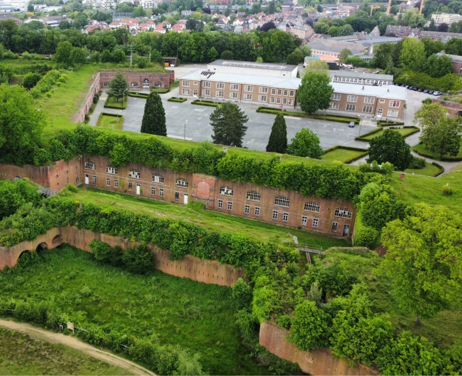 Luchtfoto van de Citadel van Diest: de bakstenen wallen met begroeide taluds, en daarachter de gebouwen en het binnenplein.